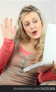 Excited blonde checking her laptop