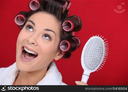 Excited brunette wearing hair-rollers