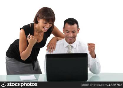 Excited business duo with laptop