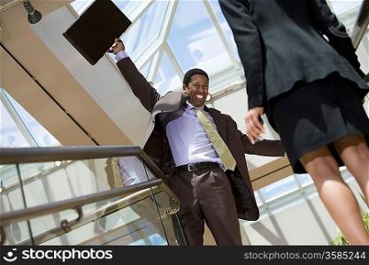Excited business man holding briefcase in office building