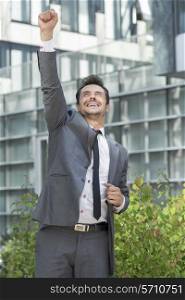 Excited businessman celebrating success outside office building