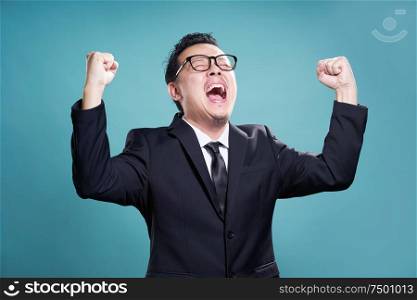 Excited businessman isolated on the cyan background .