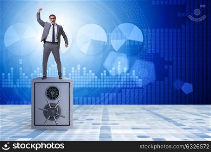 Excited businessman standing on top of safe