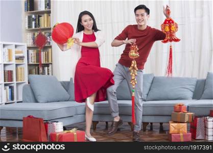 Excited couple displaying New Year ornaments