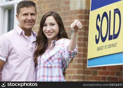 Excited Couple Outside New Home Holding Keys