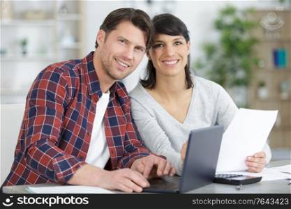 excited couple reading good news on laptop