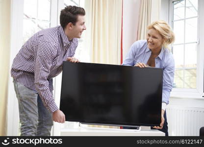 Excited Couple Setting Up New Television At Home