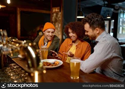 Excited diverse friends having fun watching football game online video on smartphone Three millennial multiracial young people rest in sports bar. Friends watching football game online video on smartphone rest in sports bar