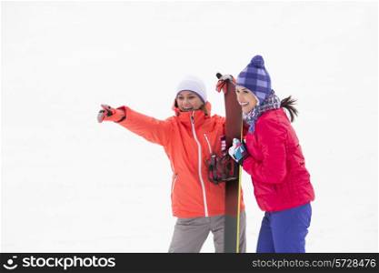 Excited female friends with snowboard outdoors
