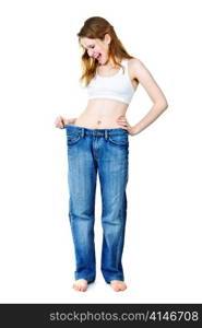 Excited fit young woman in loose old jeans after losing weight isolated on white