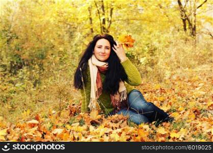 Excited happy fall woman smiling joyful and blissful holding autumn leaves outside in colorful fall forest. Young woman in beautiful autumn park, concept autumn