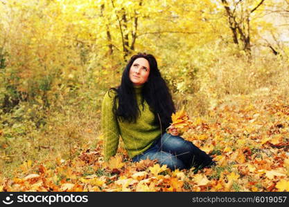 Excited happy fall woman smiling joyful and blissful holding autumn leaves outside in colorful fall forest. Young woman in beautiful autumn park, concept autumn