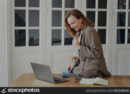 Excited happy freelancer is sitting on desk top. Elegant mid adult businesswoman is working on laptop from home. Attractive emotional european lady is entrepreneur, manager or accountant.. Excited freelancer is sitting on desk top. Elegant businesswoman is working on laptop from home.