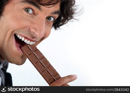 Excited man eating chocolate bar