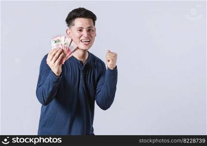 Excited man with money in his hand, astonished man with banknotes in his hand, concept of man earning money