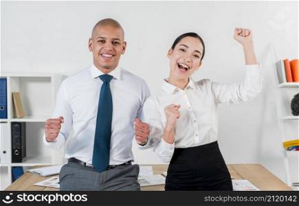 excited overjoyed young business couple standing front table workplace