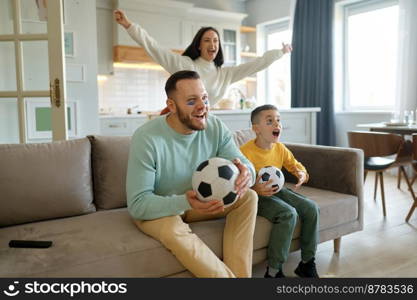 Excited parent with overjoyed child watching soccer game on tv at home. Football match, leisure and happy family sport fan pastime together. Excited parent with overjoyed child watching soccer game on tv at home