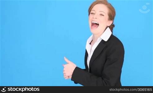 Excited smiling businesswoman giving the thumbs up gesture for approval, success, or hope, thumbs pointing to blank copyspace