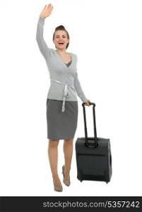 Excited traveling woman with suitcase waving hand