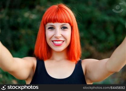 Excited woman with red hair enjoing in the forest