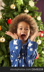 Excited Young Boy In Front Of Christmas Tree