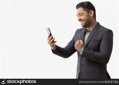 Excited young businessman looking at cell phone