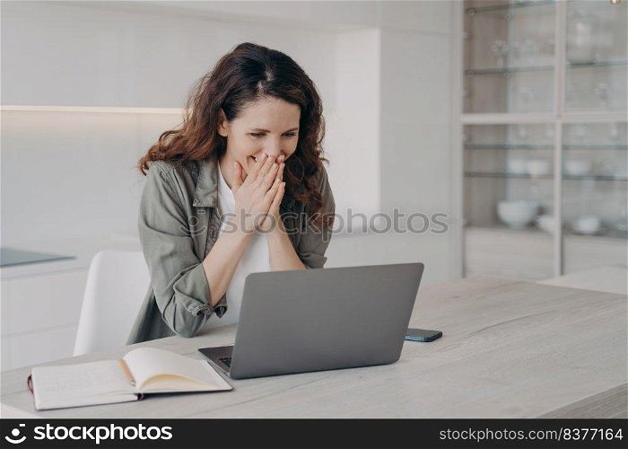 Excited young european woman has video call on laptop. Happy freelancer has corporate internet session. Hispanic girl staying home on quarantine and having good time. Businesswoman has remote work.. Excited young businesswoman has video call on laptop. Corporate internet session.