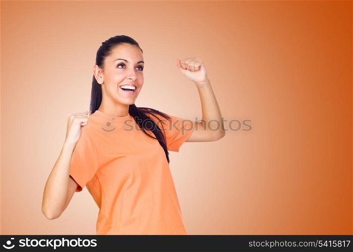 Excited Young Girl Smiling with Hands Raised on Orange Background