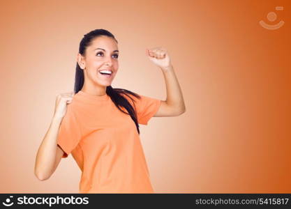 Excited Young Girl Smiling with Hands Raised on Orange Background