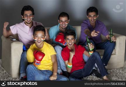Excited young male friends watching boxing match together at home