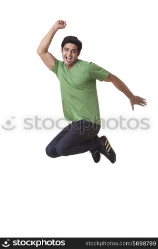 Excited young man jumping over white background