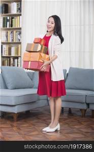 Excited young woman holding New Year gift boxes