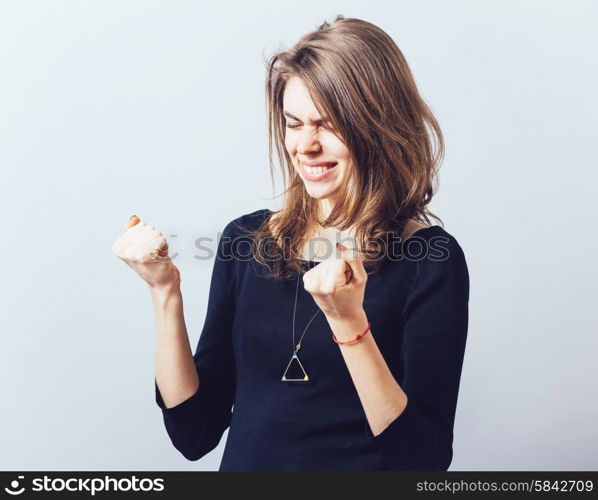 Excited young woman with fists up