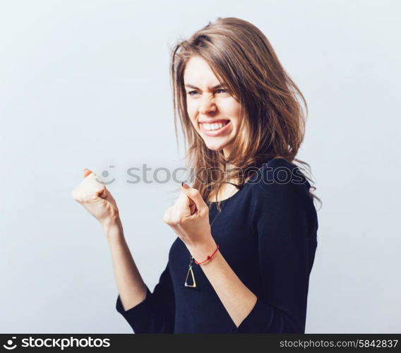 Excited young woman with fists up