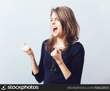 Excited young woman with fists up