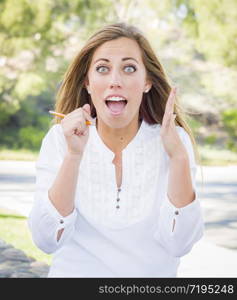 Excited Young Woman With Pencil Outdoors at the Park.