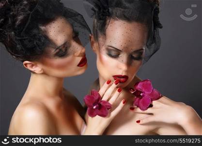 Excitement. Two Voluptuous Ladies with Purple Orchid Flowers Flirting