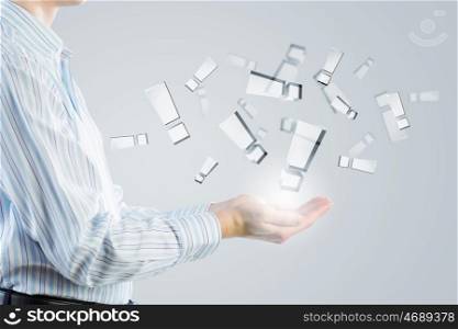 Exclamation sign in hands. Businessman holding in palms glass exclamation symbols