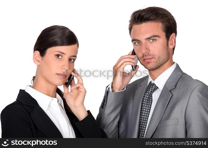 Executive couple using cellphones