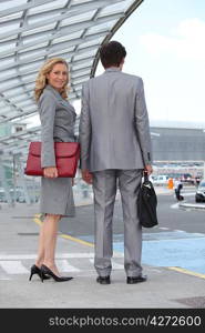 Executive couple waiting for taxi