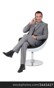 Executive in a swivel chair talking on a cellphone