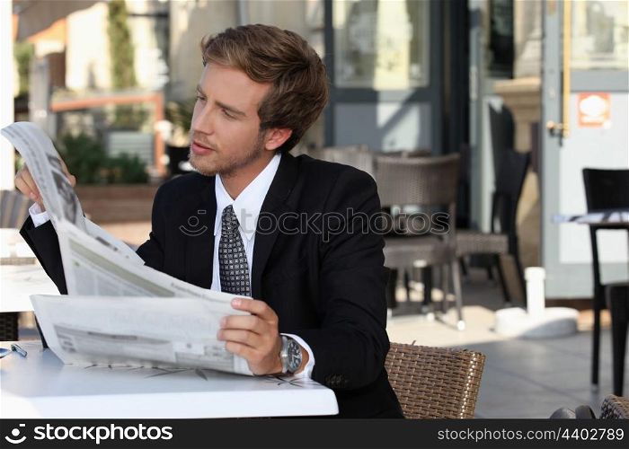 Executive reading a newspaper on the terrace