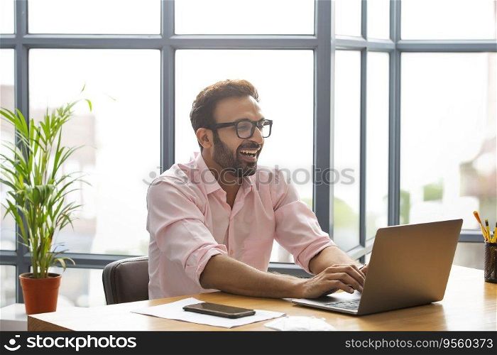 Executive smiling while working on his laptop