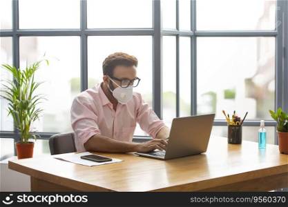 Executive wearing a face mask working on his laptop
