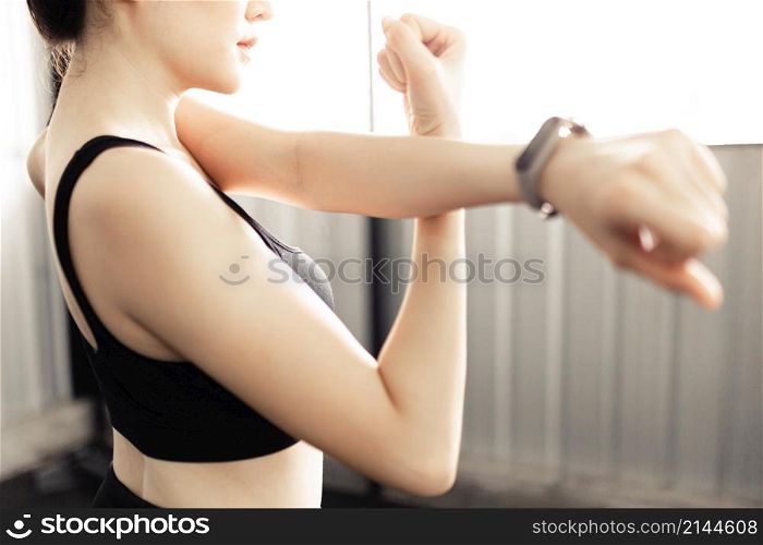 exercise concept The lady who has got black hair and wears a grey smartwatch doing arm stretching by support her left arm with the wrist of her right arm.