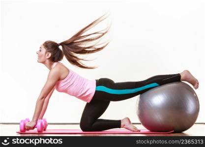 Exercise sport fitness health concept. Fit girl exercising. Attractive female warming up with ball and dumb bell weights.. Fit girl exercising.