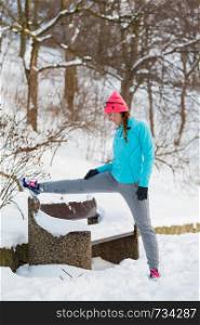 Exercises in winter aura, girl doing streches in winter park. Fitness health fashion concept. Exercises in winter aura
