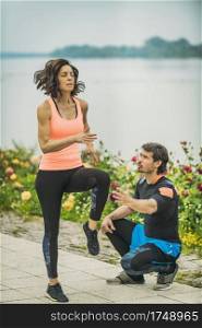 Exercising by the river with personal trainer. Female Exercising by the River with Personal Fitness Trainer