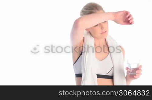 exhausted blonde woman drinking water after workout