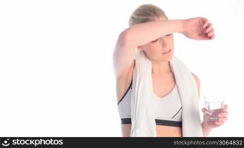 exhausted blonde woman drinking water after workout